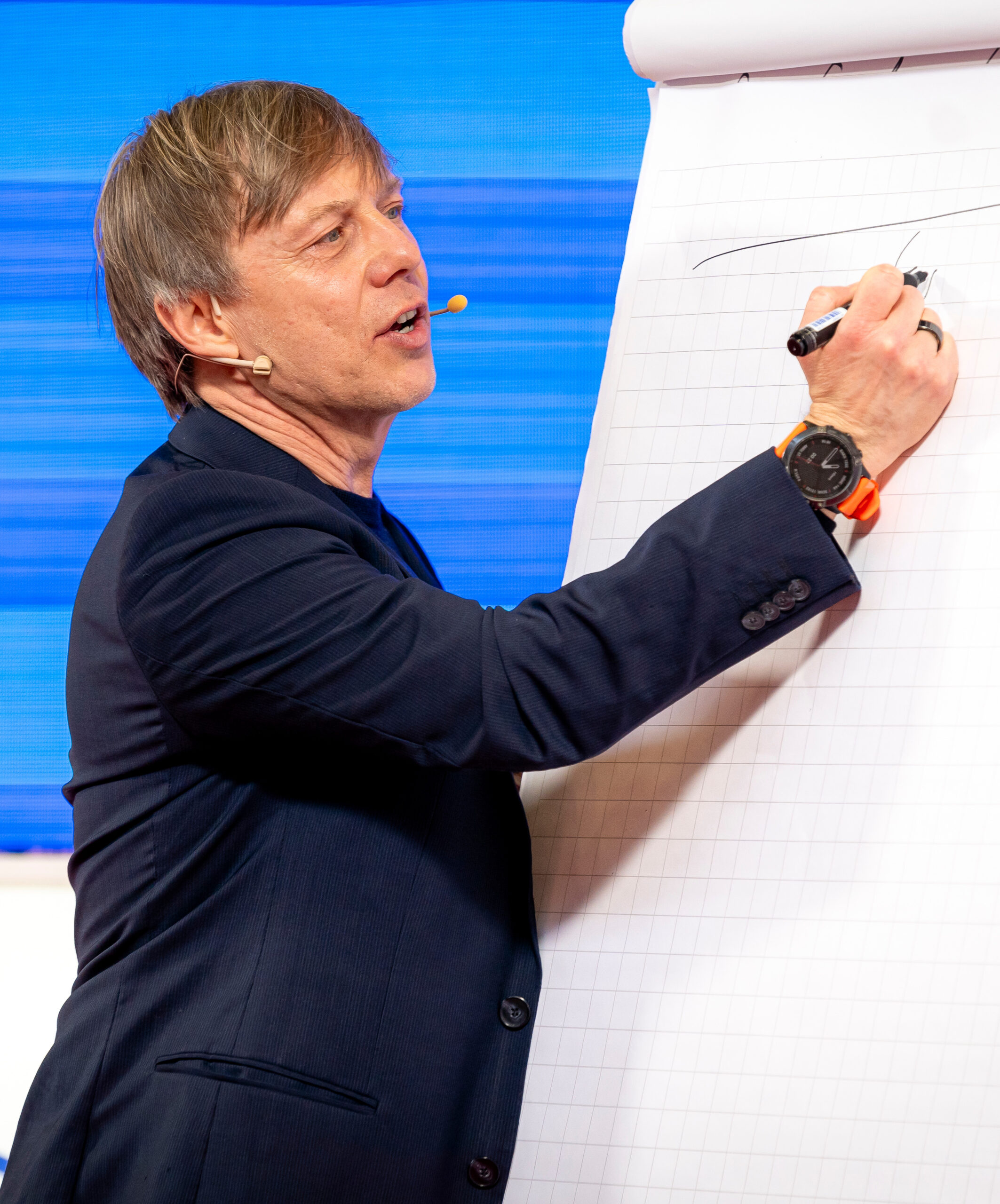 Lutz Ramlich erklärt an einem Flipchart einen Kurvenverlauf, Didacta 2024